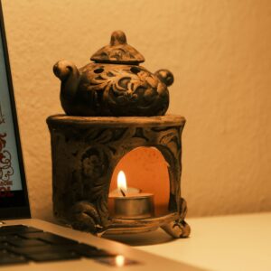 A serene candlelit workspace with a decorative lamp beside a laptop, ideal for a cozy atmosphere.
