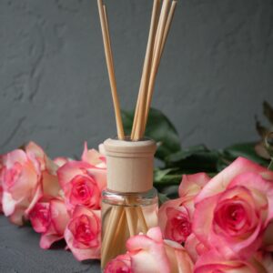 Aromatic reed diffuser and vibrant roses create a serene ambiance.