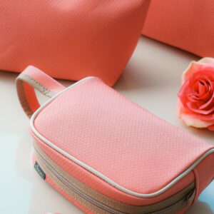 Pink cosmetic bags beautifully arranged with roses, perfect for a stylish display or mobile wallpaper.