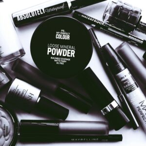 Elegant monochrome flatlay showcasing a collection of beauty products and cosmetics.