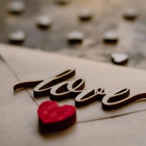 Close-up of a love letter with 'love' text and red heart for Valentine's Day.