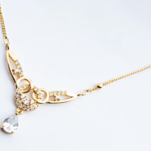 Luxury gold necklace featuring diamond accents on a white background.