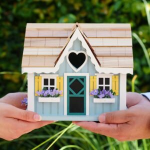 Close-up of hands holding a detailed miniature house model, symbolizing goals of homeownership.