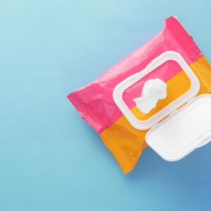 Brightly colored wet wipes package on a blue surface, symbolizing hygiene and cleanliness.