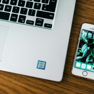 pexels-photo-2473650-2473650 Close-up of a laptop and smartphone on a wooden desk in an office setting.