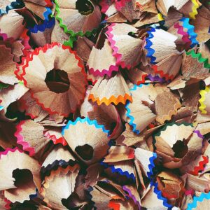 A collage of colorful pencil shavings creating a vibrant abstract pattern.