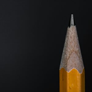 Detailed view of a sharpened pencil against a dark background, showcasing texture and sharpness.
