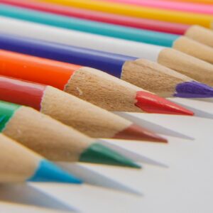 Colorful close-up of sharpened colored pencils neatly arranged on a white surface.