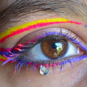 pexels-photo-17423809-17423809 Close-up of an eye with vibrant makeup and a decorative tear drop.