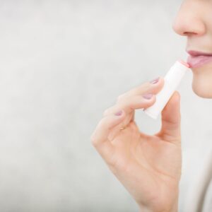 pexels-photo-374622-374622 Close-up of a young woman applying lip balm for lip care and protection.
