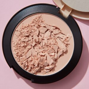 pexels-photo-7256133-7256133 Close-up of crushed cosmetic powder in container against pink backdrop, showcasing texture and details.