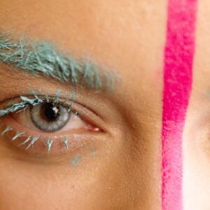 pexels-photo-7314075-7314075 Close-up of vibrant makeup with blue eyebrows and pink line highlighting creativity and style.